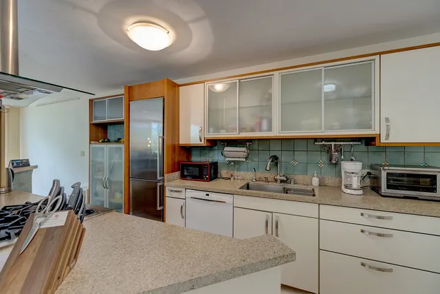 a kitchen with a sink stainless steel appliances and cabinets