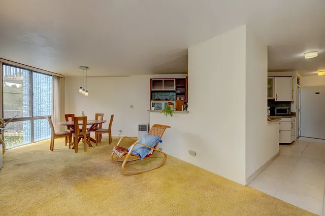 a dining room with furniture and a floor to ceiling window