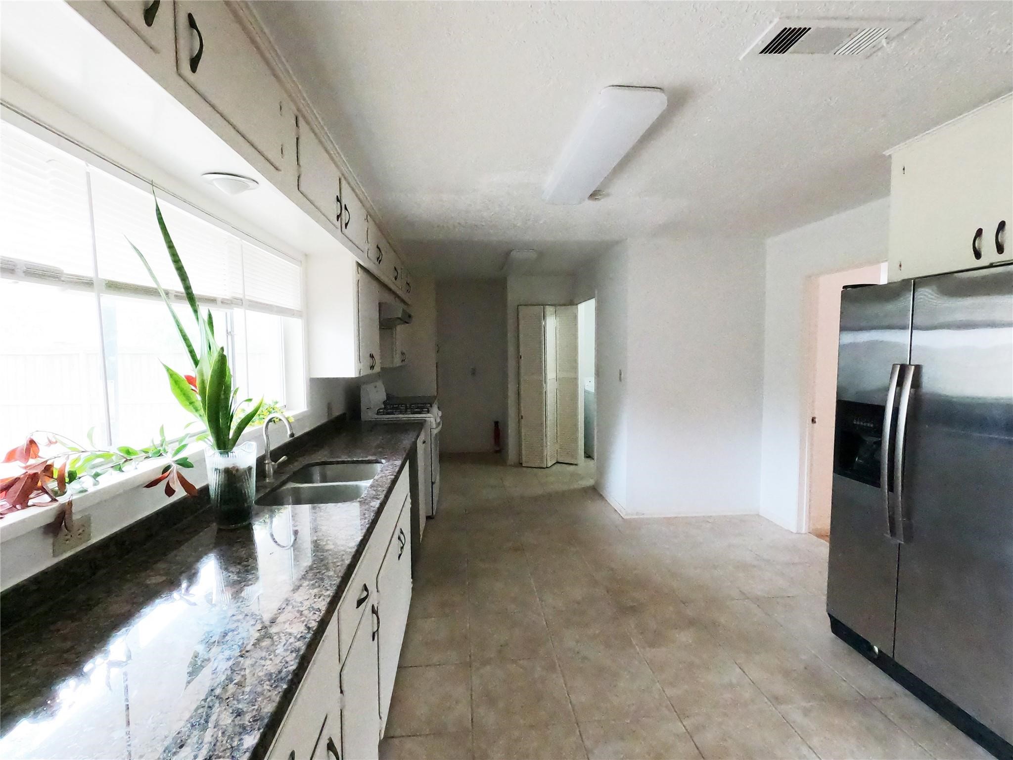5231 Beechnut Street Houston, TX 77096 - Photo 14 of 19 a kitchen with stainless steel appliances granite countertop a sink a stove and a refrigerator