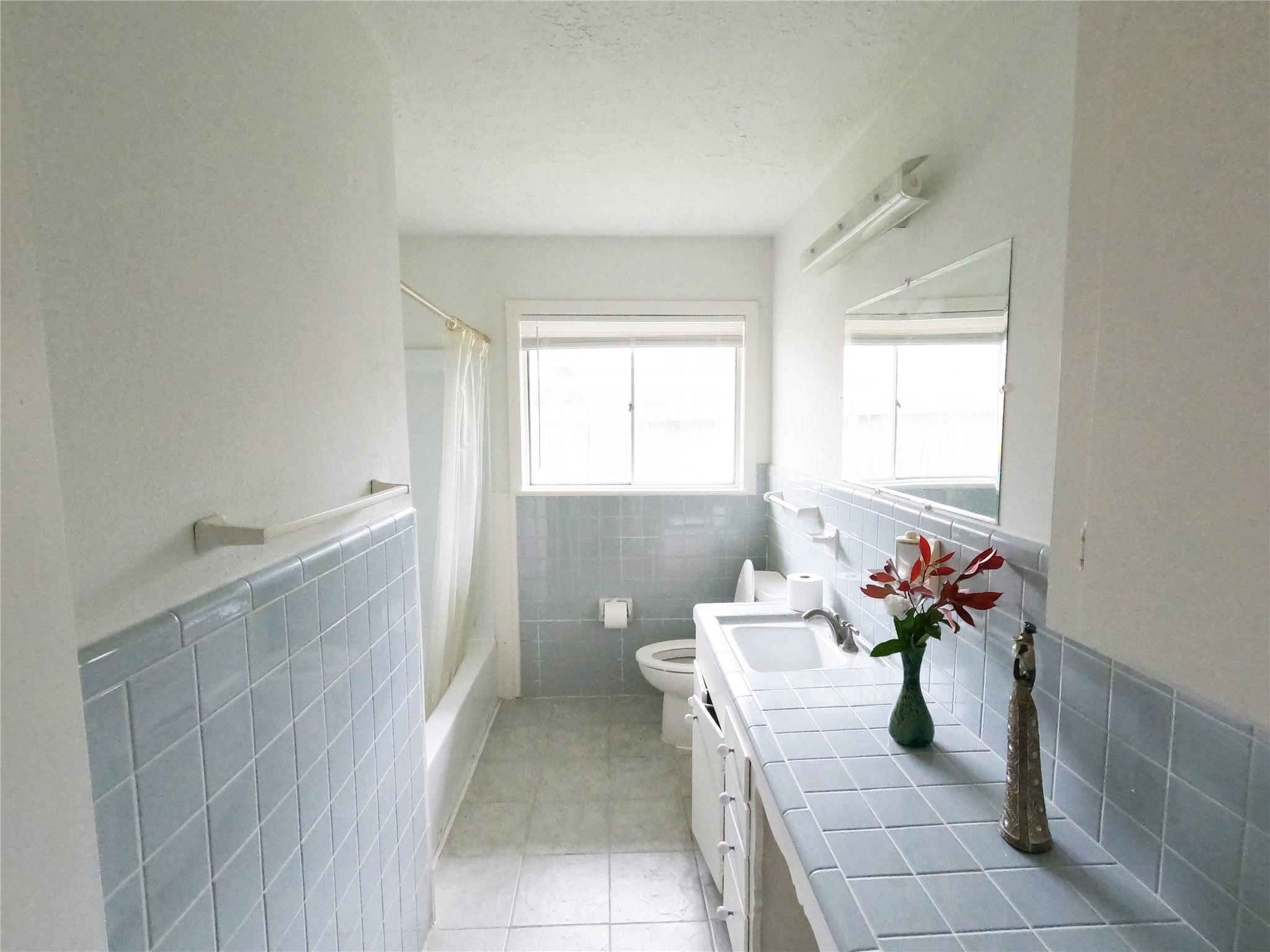 5231 Beechnut Street Houston, TX 77096 - Photo 10 of 19 a living room with furniture and flowers