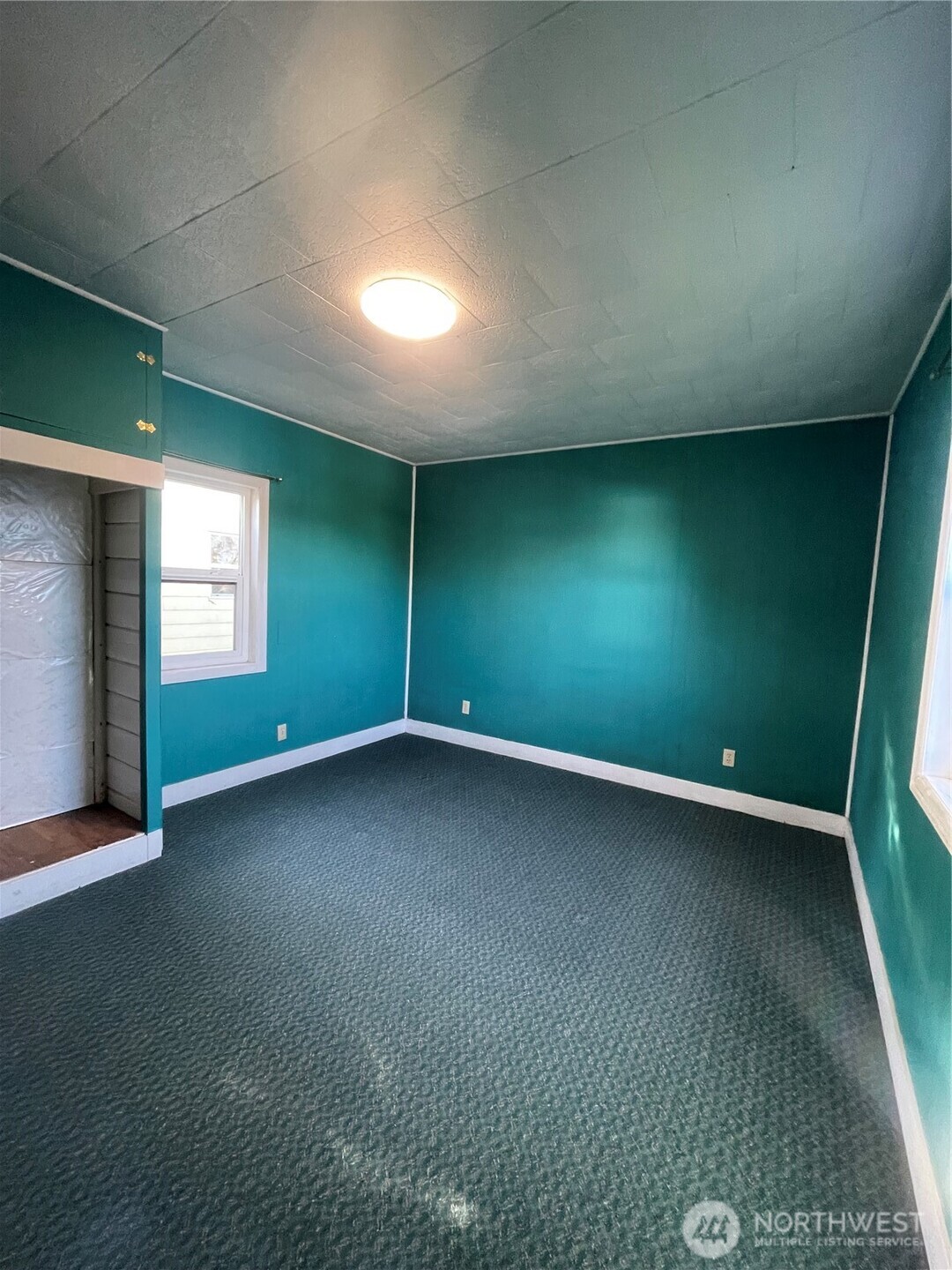 1052 Ballentine Street Raymond, WA 98577 - Photo 11 of 14 an empty room with a fireplace and window
