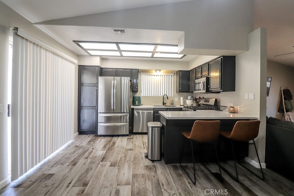 1330 Santa Fe Circle Needles, CA 92363 - Photo 10 of 28 a kitchen with stainless steel appliances granite countertop a refrigerator a sink dishwasher a stove and white countertops with wooden floor