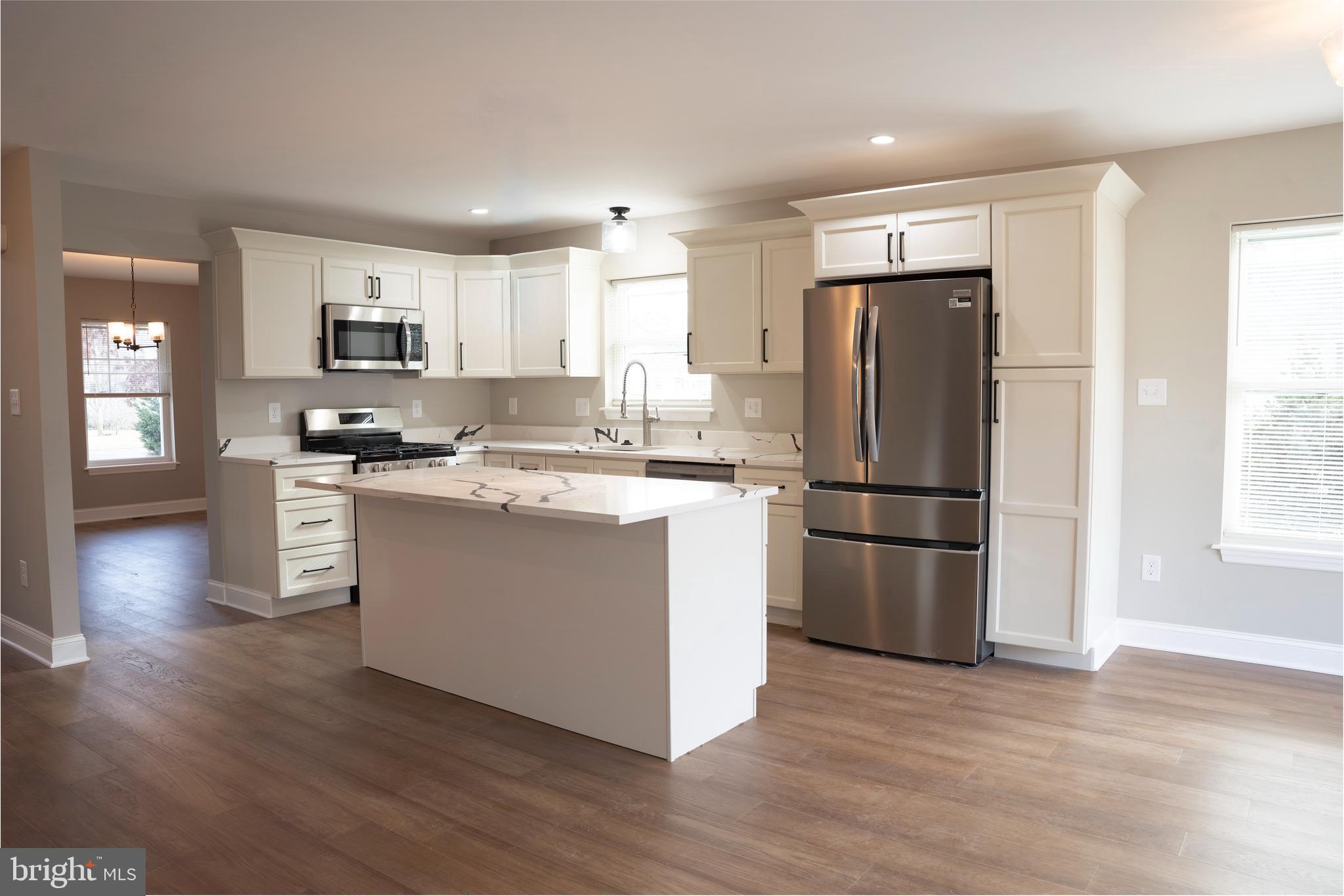 702 Delaware Avenue Riverside, NJ 08075 - Photo 2 of 15 a kitchen with stainless steel appliances granite countertop a refrigerator a sink a stove a microwave and white cabinets with wooden floor
