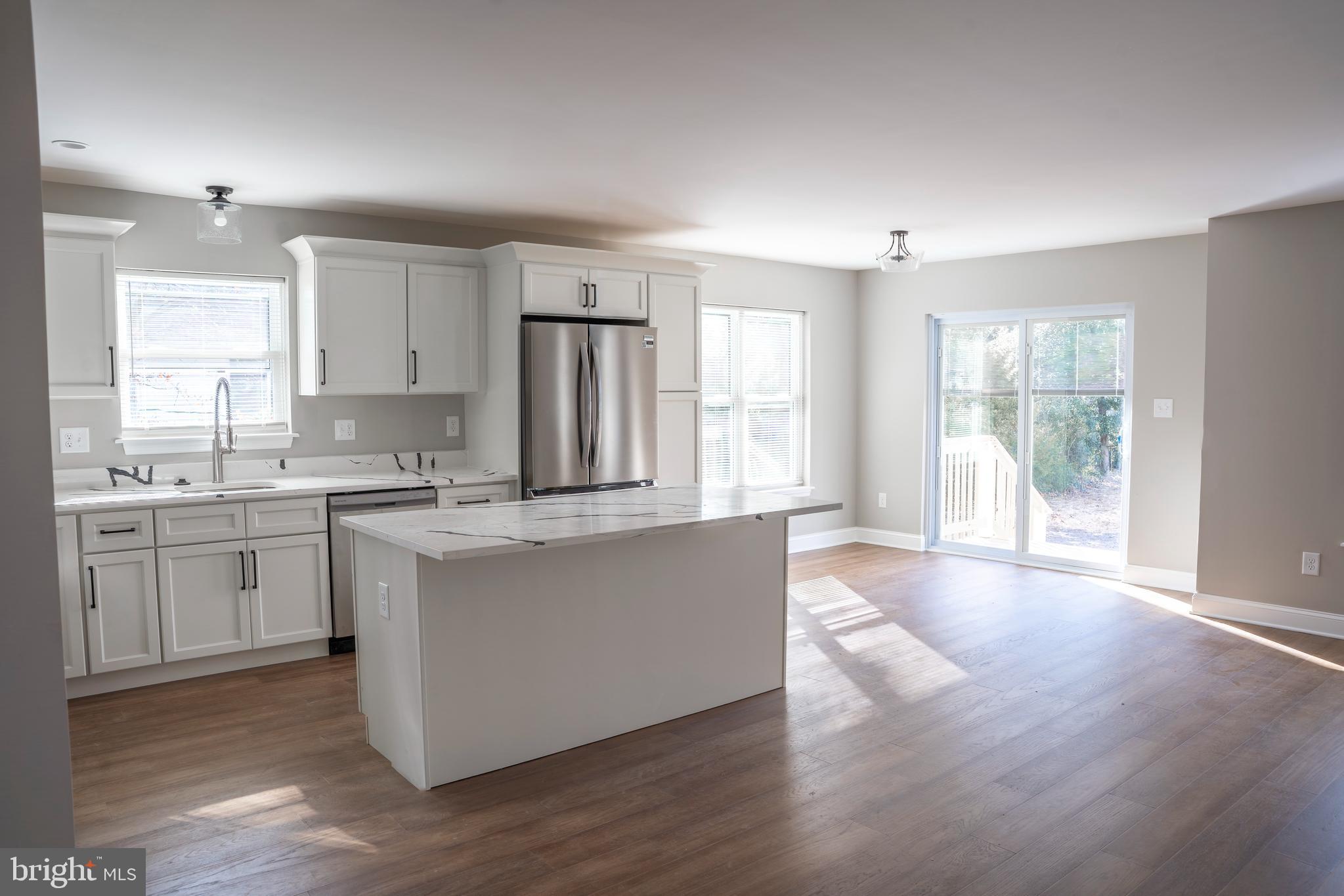702 Delaware Avenue Riverside, NJ 08075 - Photo 3 of 15 a open kitchen with granite countertop a stove top oven sink and white cabinets with wooden floor