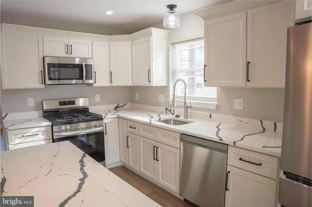 a kitchen with appliances a sink and cabinets
