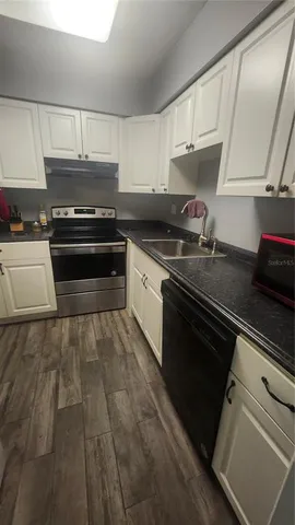 a kitchen with granite countertop a stove and a sink
