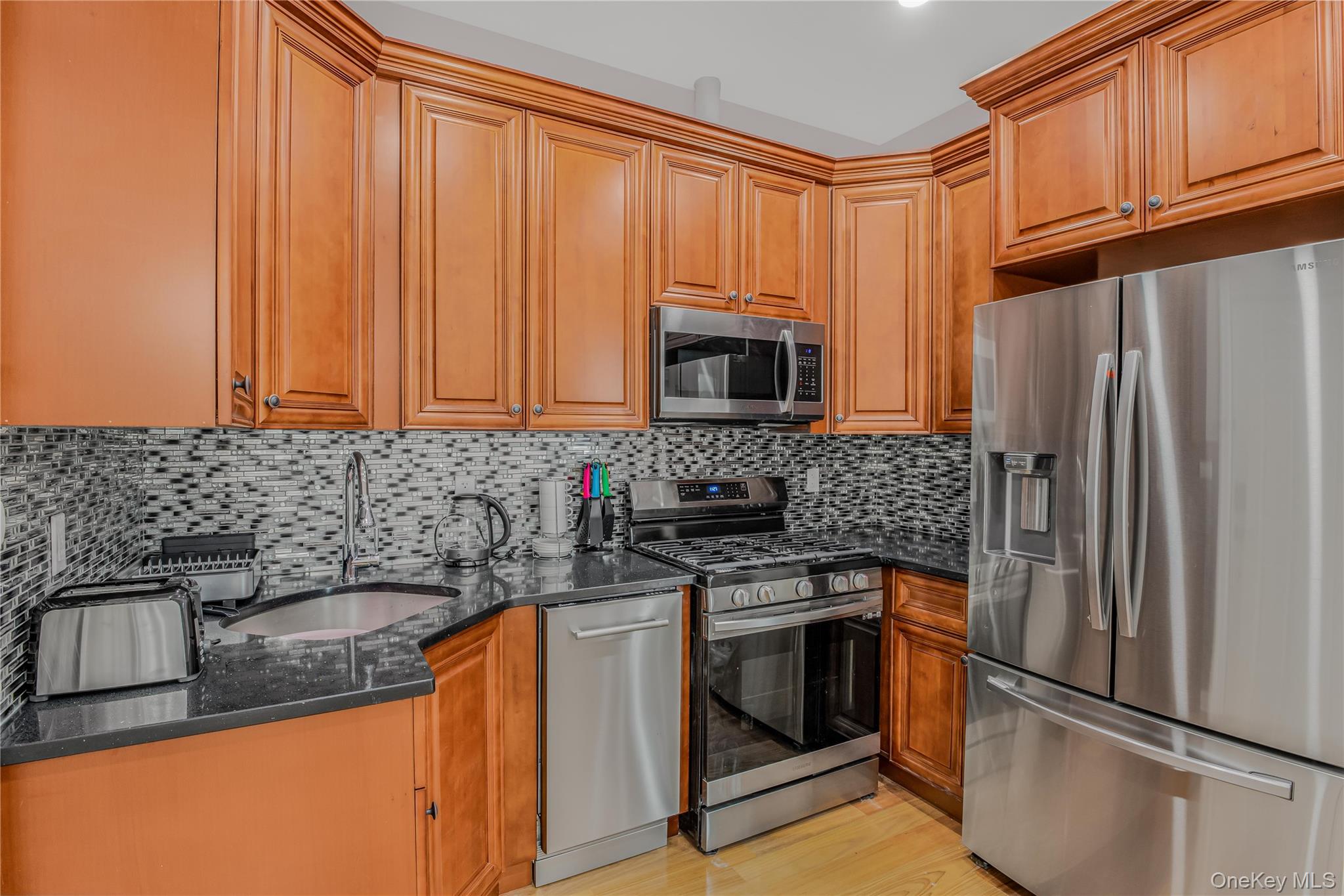 43-47 44th Street, Unit 3F Queens, NY 11104 - Photo 6 of 17 a kitchen with stainless steel appliances granite countertop a refrigerator stove a sink and dishwasher
