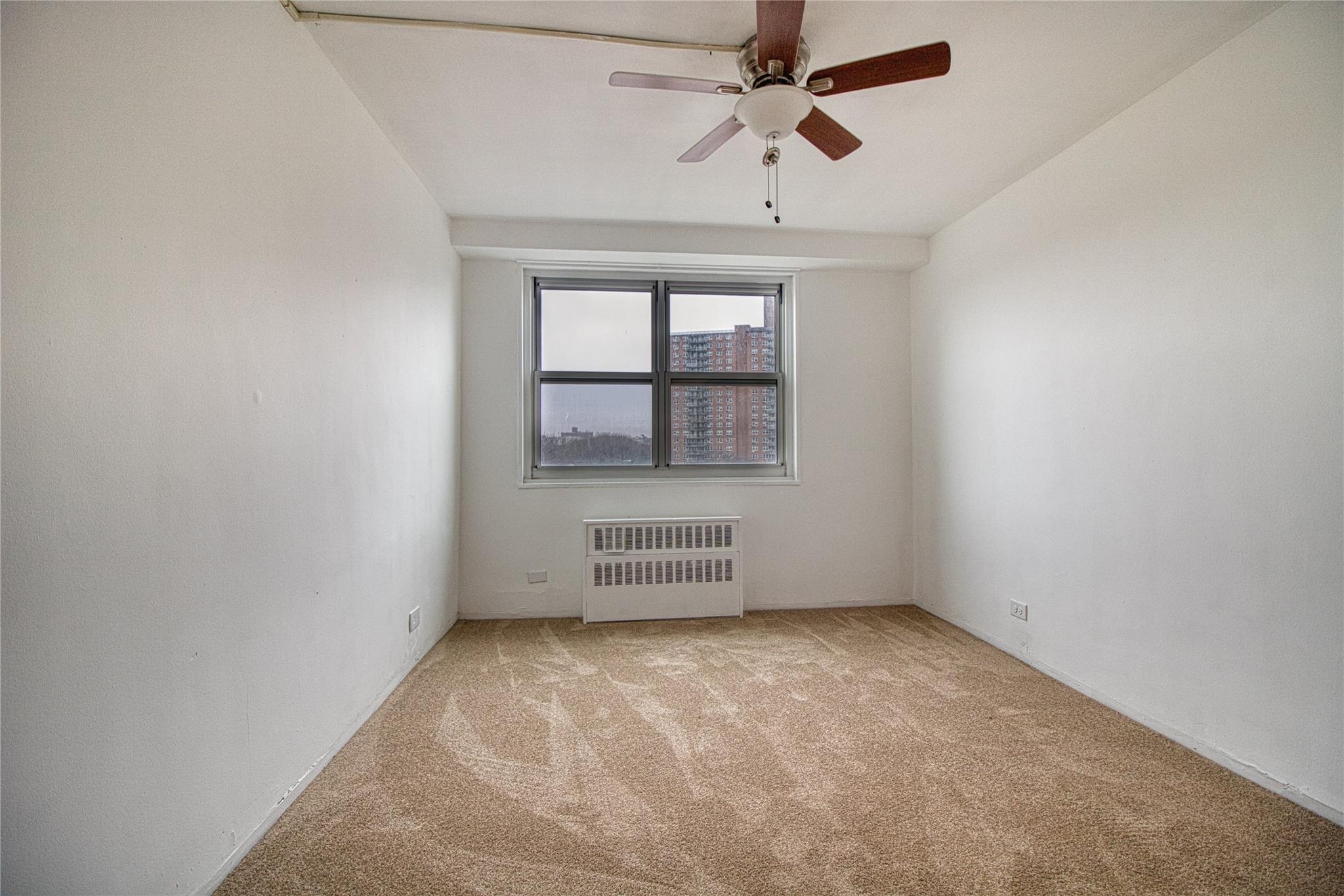 825 Morrison Avenue, Unit 6F Bronx, NY 10473 - Photo 4 of 12 Carpeted empty room featuring radiator and a ceiling fan