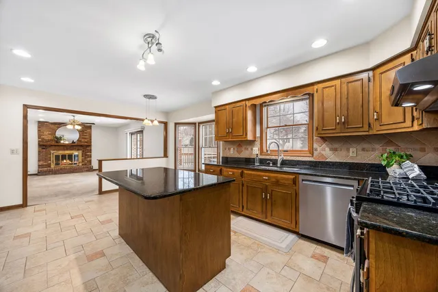 a kitchen with stainless steel appliances granite countertop a sink and a stove
