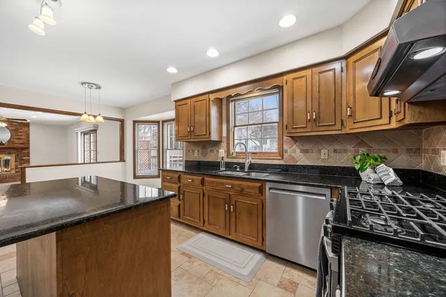 a kitchen with stainless steel appliances granite countertop a sink stove and cabinets