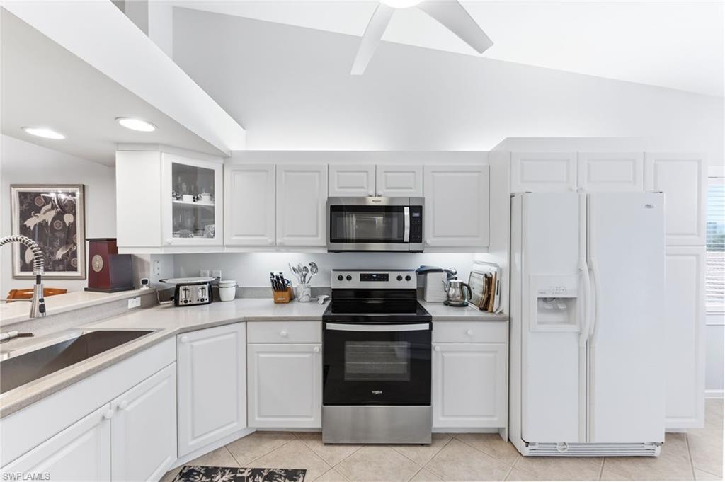 6840 Beach Resort Drive, Unit 16 Naples, FL 34114 - Photo 13 of 49 Kitchen with stainless steel appliances, lofted ceiling, white cabinets, glass fronted cabinets, and a ceiling fan