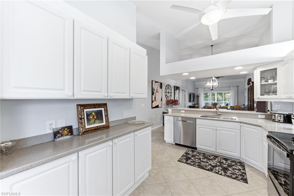 6840 Beach Resort Drive, Unit 16 Naples, FL 34114 - Photo 17 of 49 Kitchen featuring white cabinets, stainless steel dishwasher, a ceiling fan, a peninsula, and a high ceiling
