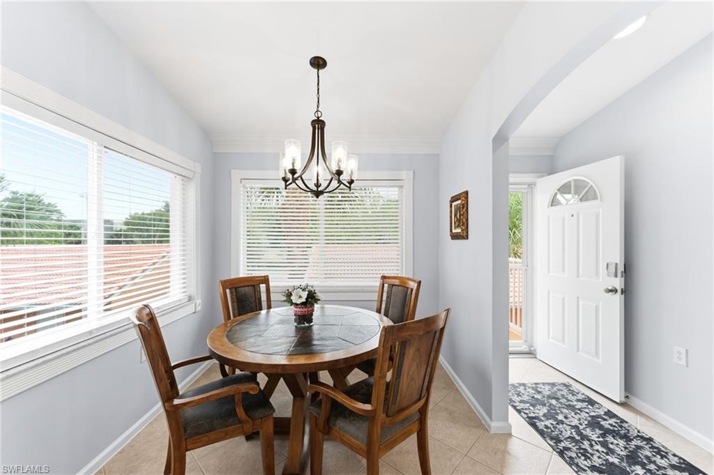 6840 Beach Resort Drive, Unit 16 Naples, FL 34114 - Photo 19 of 49 Dining area featuring vaulted ceiling, light tile patterned flooring, hanging lights, and arched walkways