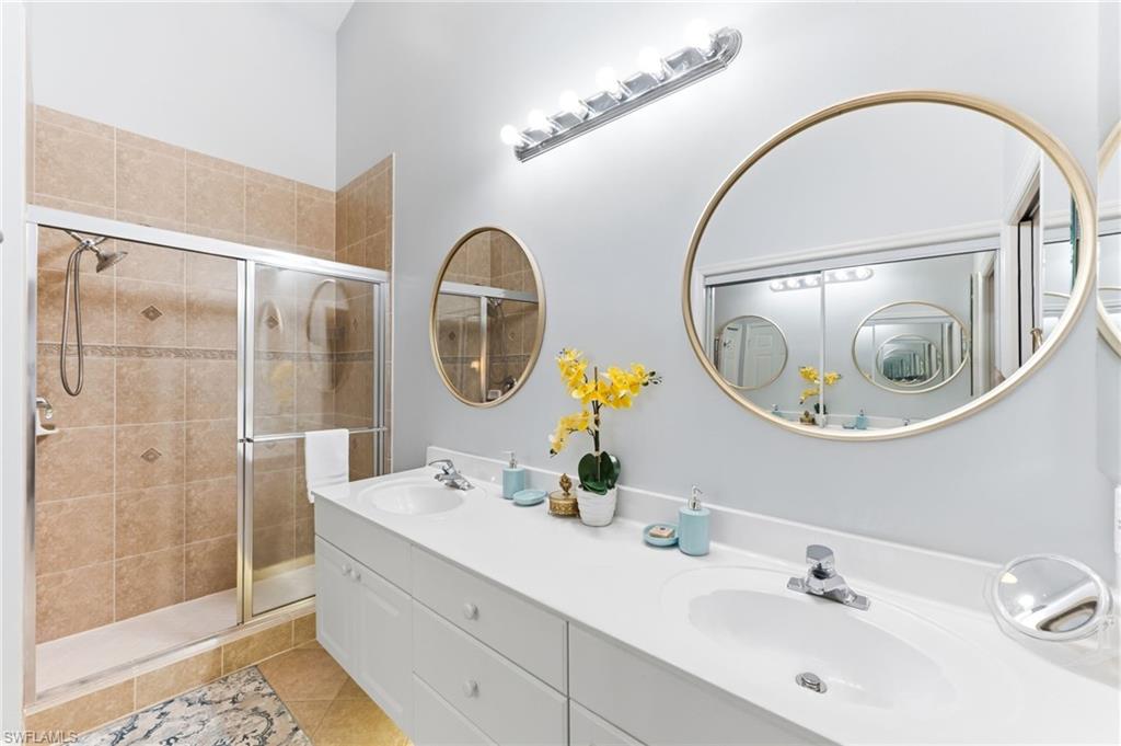 6840 Beach Resort Drive, Unit 16 Naples, FL 34114 - Photo 26 of 49 Full bathroom featuring double vanity, a shower stall, and light tile patterned floors