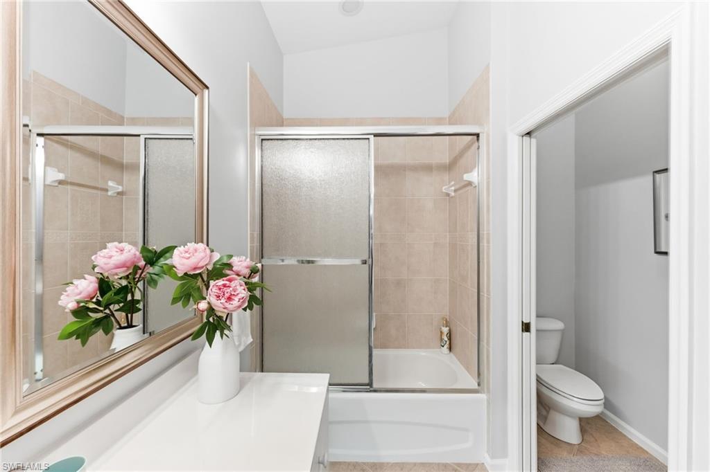 6840 Beach Resort Drive, Unit 16 Naples, FL 34114 - Photo 28 of 49 Bathroom with vanity, bath / shower combo with glass door, and light tile patterned floors