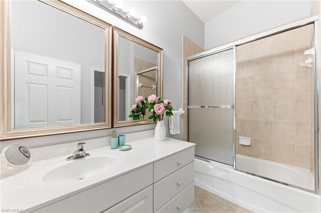 6840 Beach Resort Drive, Unit 16 Naples, FL 34114 - Photo 29 of 49 Bathroom with vanity, enclosed tub / shower combo, and light tile patterned floors