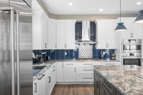 a kitchen with stainless steel appliances granite countertop a sink and stove