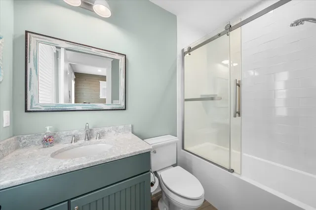 a bathroom with a granite countertop sink toilet and shower