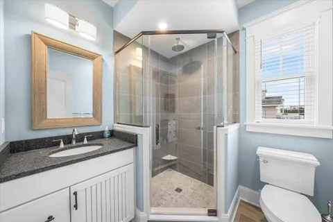 a bathroom with a granite countertop sink toilet and shower