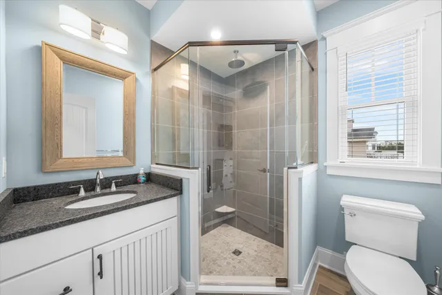 a bathroom with a granite countertop sink toilet and shower
