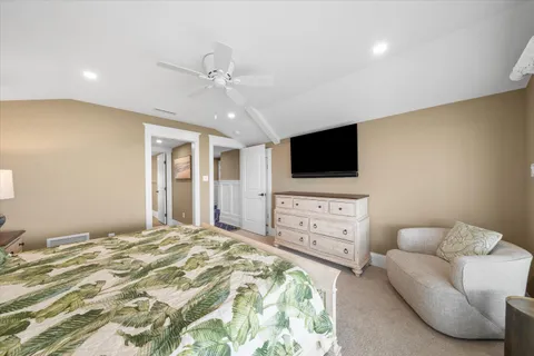 a bedroom with a bed flat screen tv and a couch