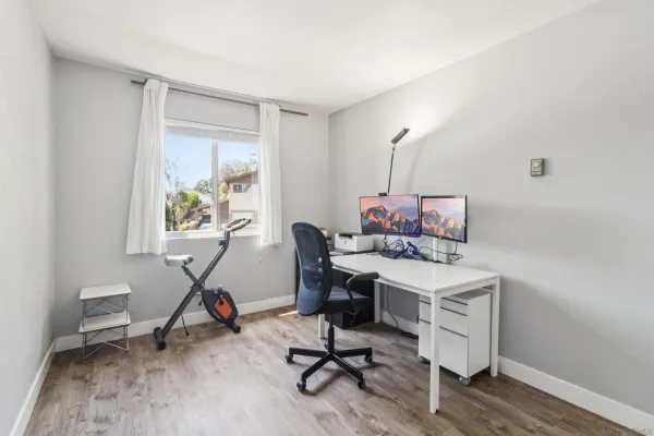 a view of a workspace with furniture and a window