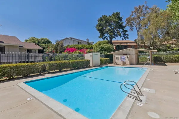 a view of a pool and a yard in front of the house