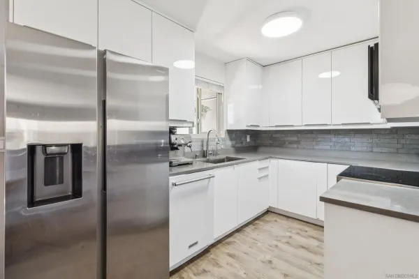 a kitchen with stainless steel appliances granite countertop a refrigerator and a sink
