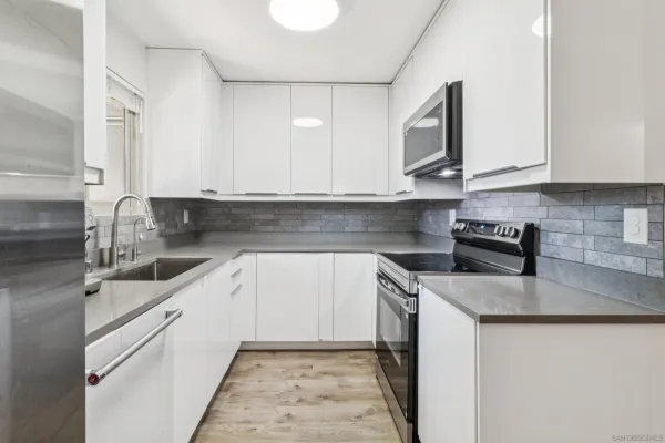 a kitchen with stainless steel appliances granite countertop a sink stove and microwave