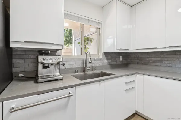 a kitchen with kitchen island a sink wooden floor and a large window