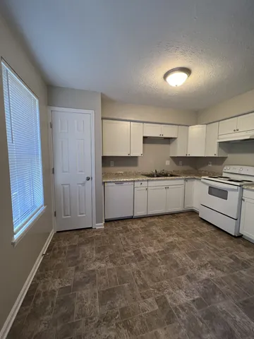 a kitchen with granite countertop a sink stainless steel appliances and cabinets