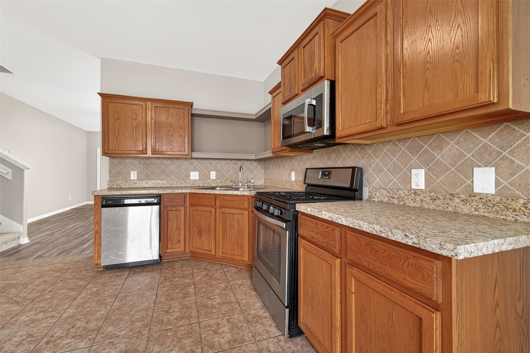 21327 Bella Flora Court Spring, TX 77379 - Photo 16 of 50 a kitchen with stainless steel appliances granite countertop a sink stove and microwave