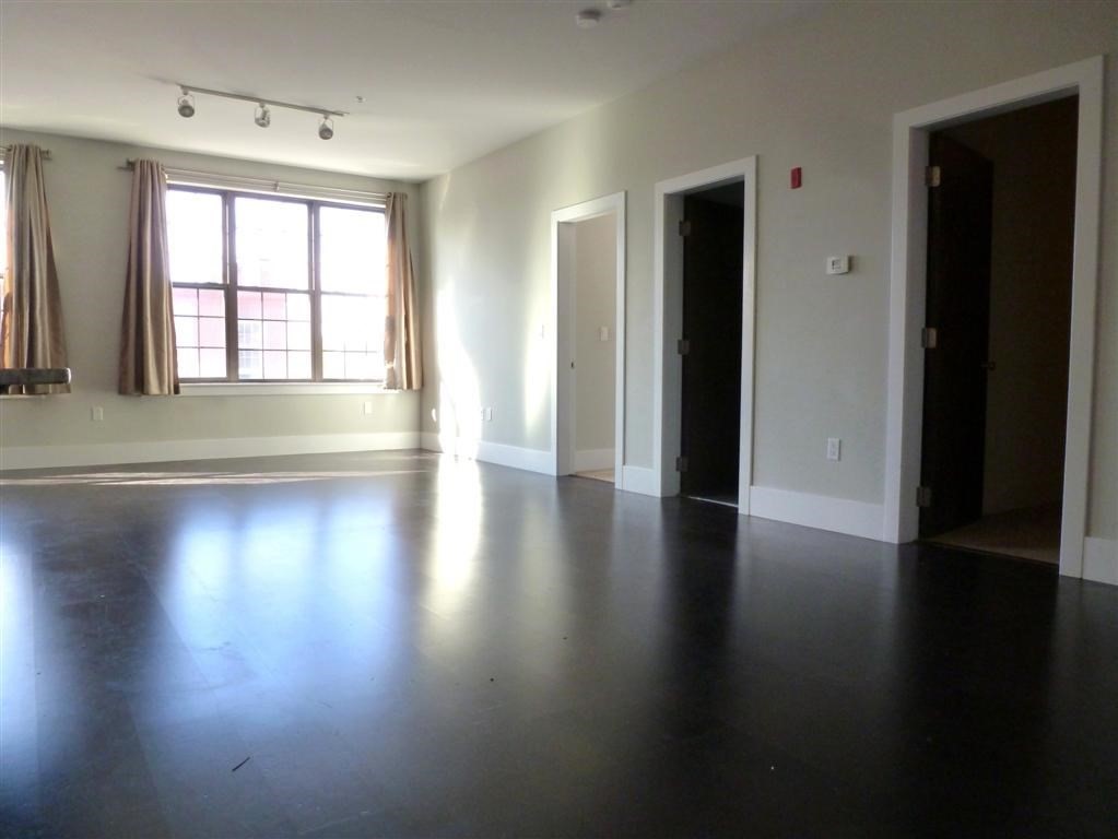 154 West 2nd Street, Unit 301 Boston, MA 02127 - Photo 6 of 13 an empty room with wooden floor and windows