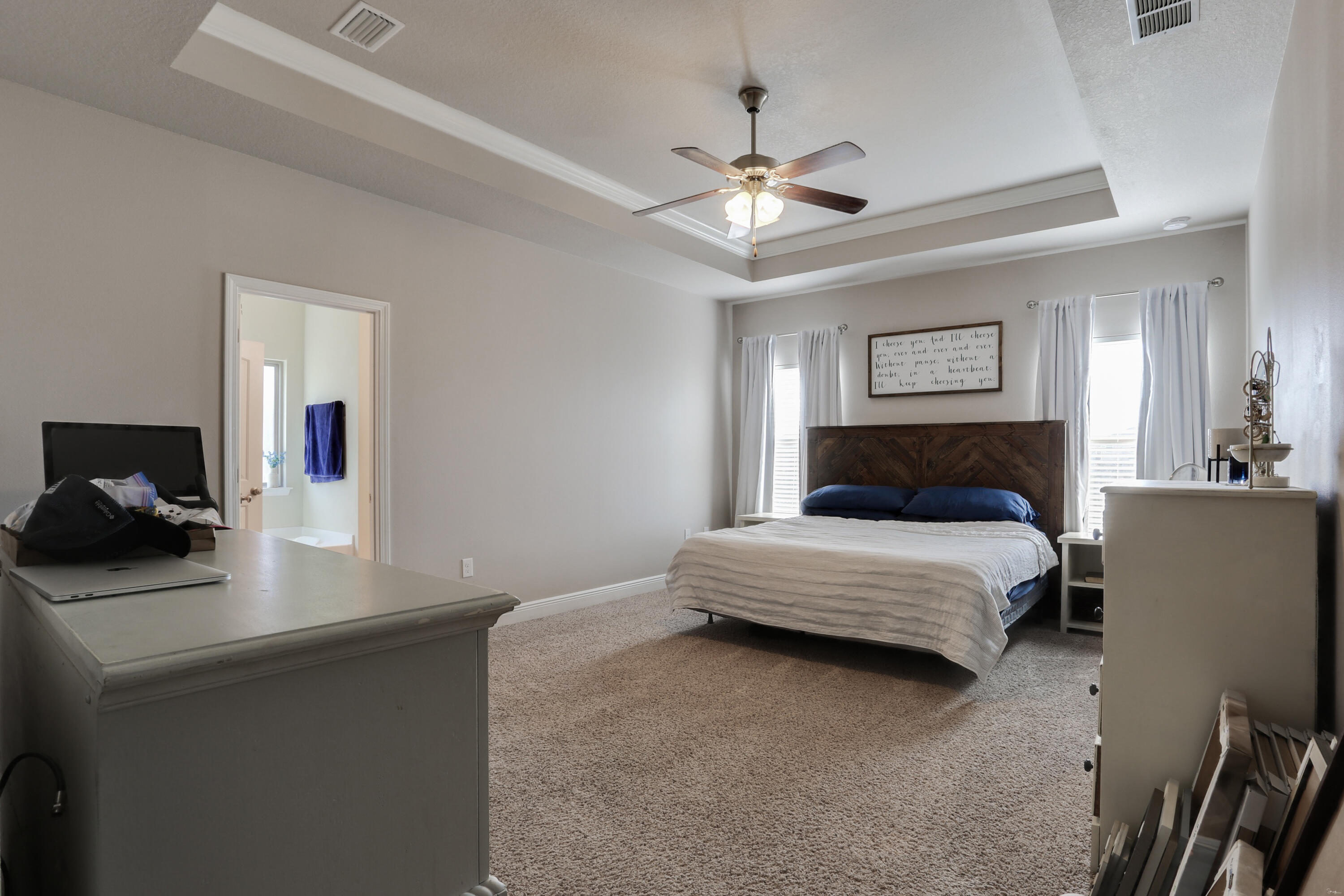 671 Teal Street Crestview, FL 32539 - Photo 28 of 41 a bedroom with a large bed and a chandelier