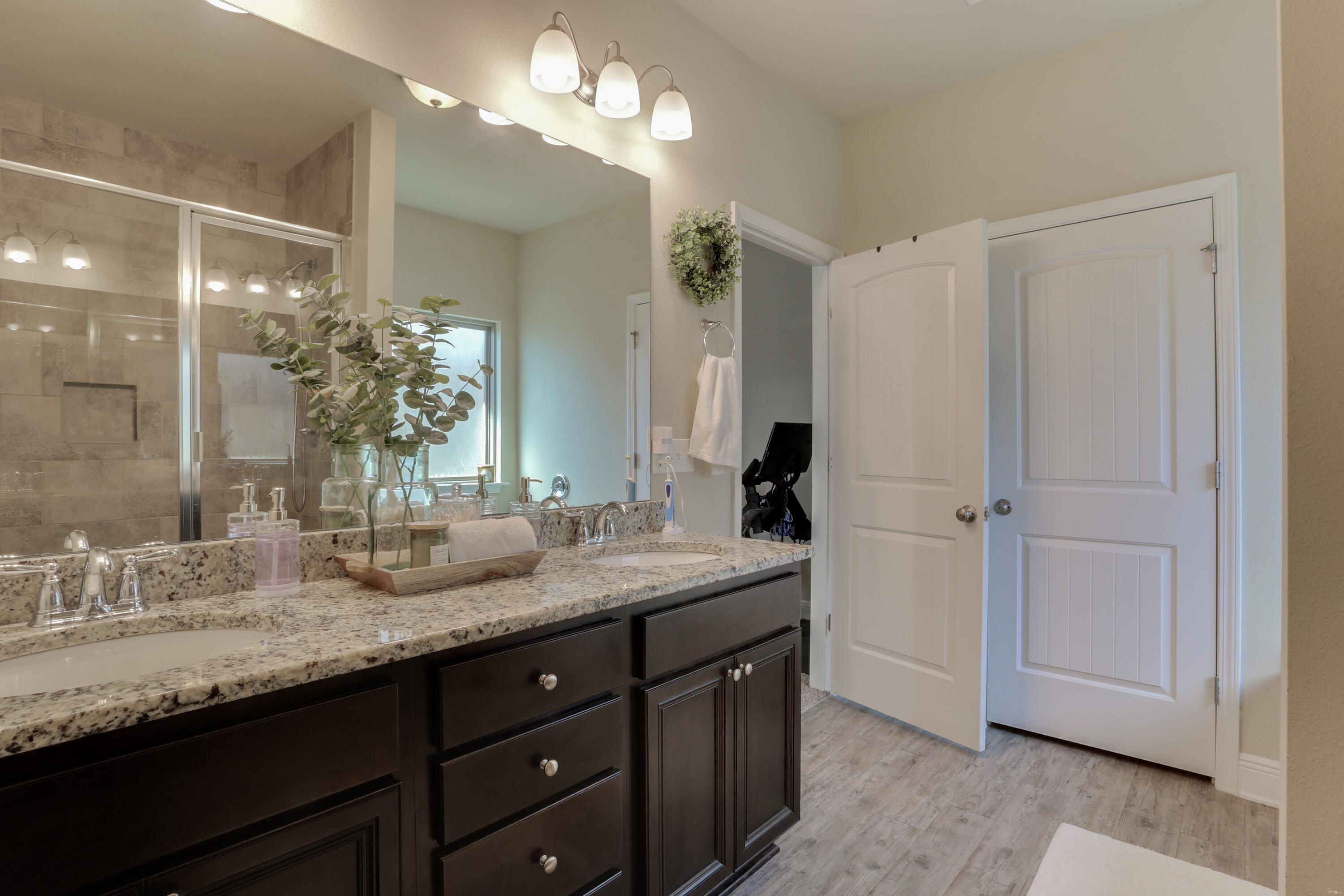 671 Teal Street Crestview, FL 32539 - Photo 32 of 41 a bathroom with a granite countertop sink a large mirror and a shower