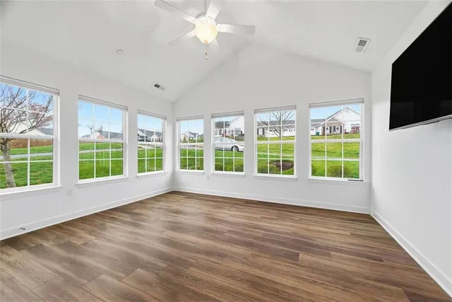 a view of room with window ceiling fan and wooden floor