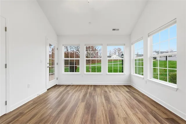 a view of empty room with wooden floor and ceiling fan