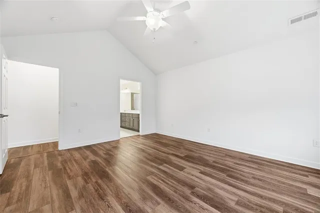 a view of empty room with wooden floor and ceiling fan