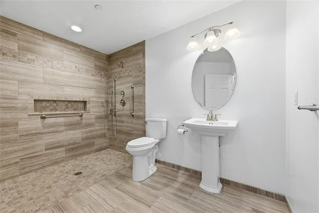 a bathroom with a toilet a sink and mirror