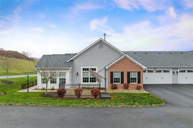 a front view of a house with a garden and yard
