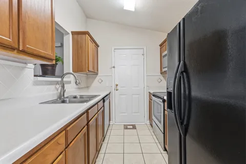 a kitchen with a sink stove and refrigerator