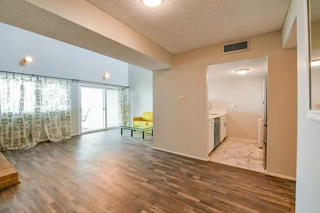 a view of a room with wooden floor and a tub