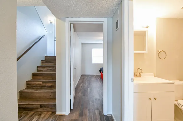 a view of a hallway with wooden floor and entryway