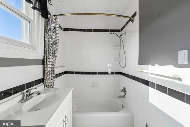a bathroom with a tub sink and mirror