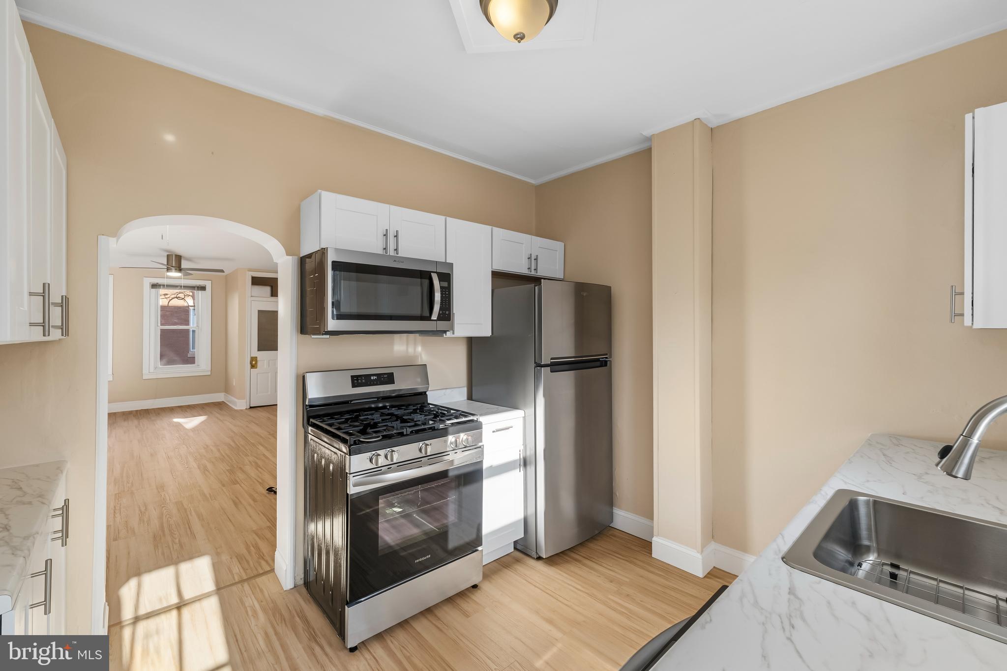 3061 Livingston Street Philadelphia, PA 19134 - Photo 9 of 28 a kitchen with granite countertop a stove and a sink