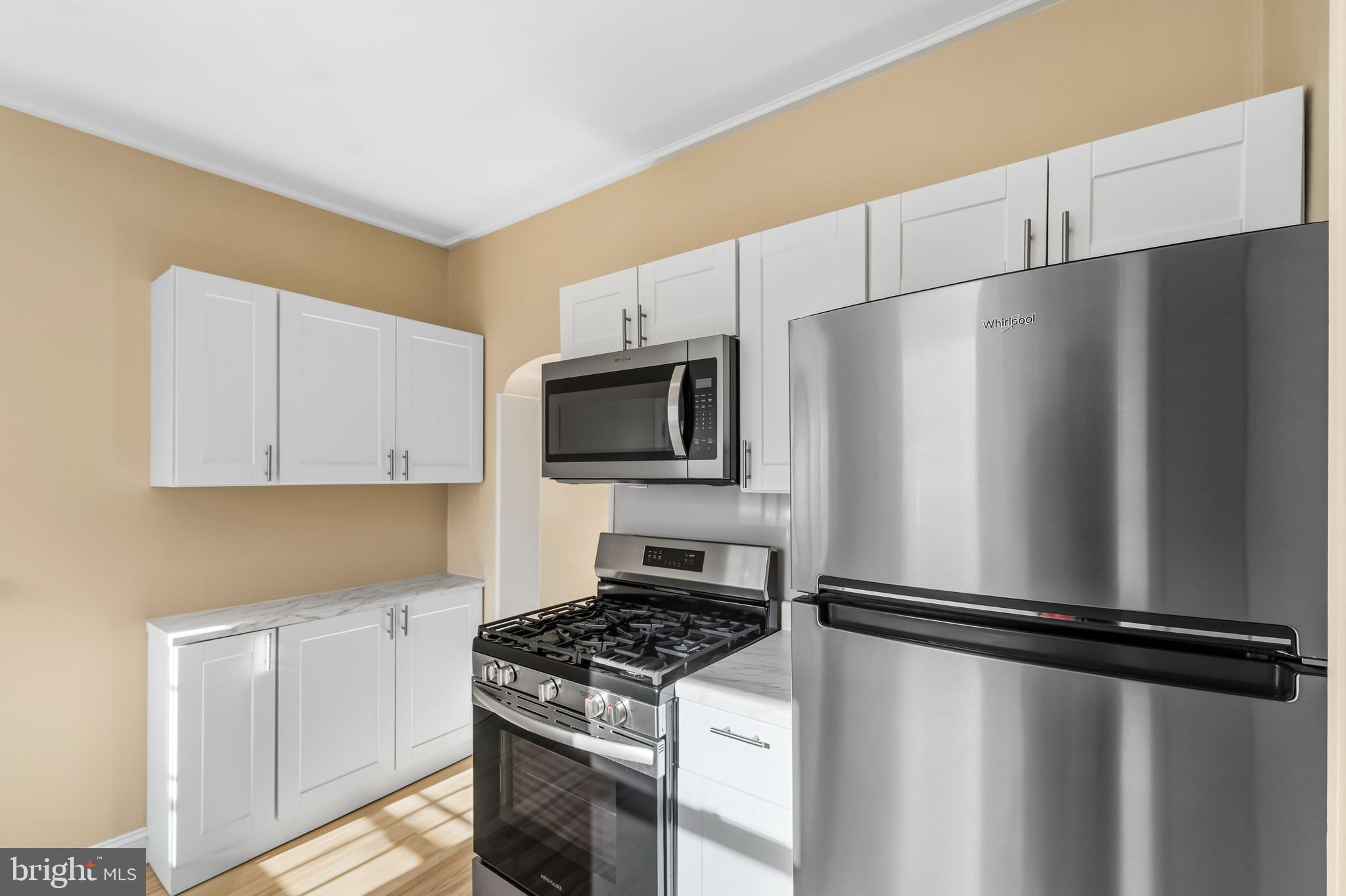 3061 Livingston Street Philadelphia, PA 19134 - Photo 10 of 28 a kitchen with a refrigerator a stove top oven and white cabinets