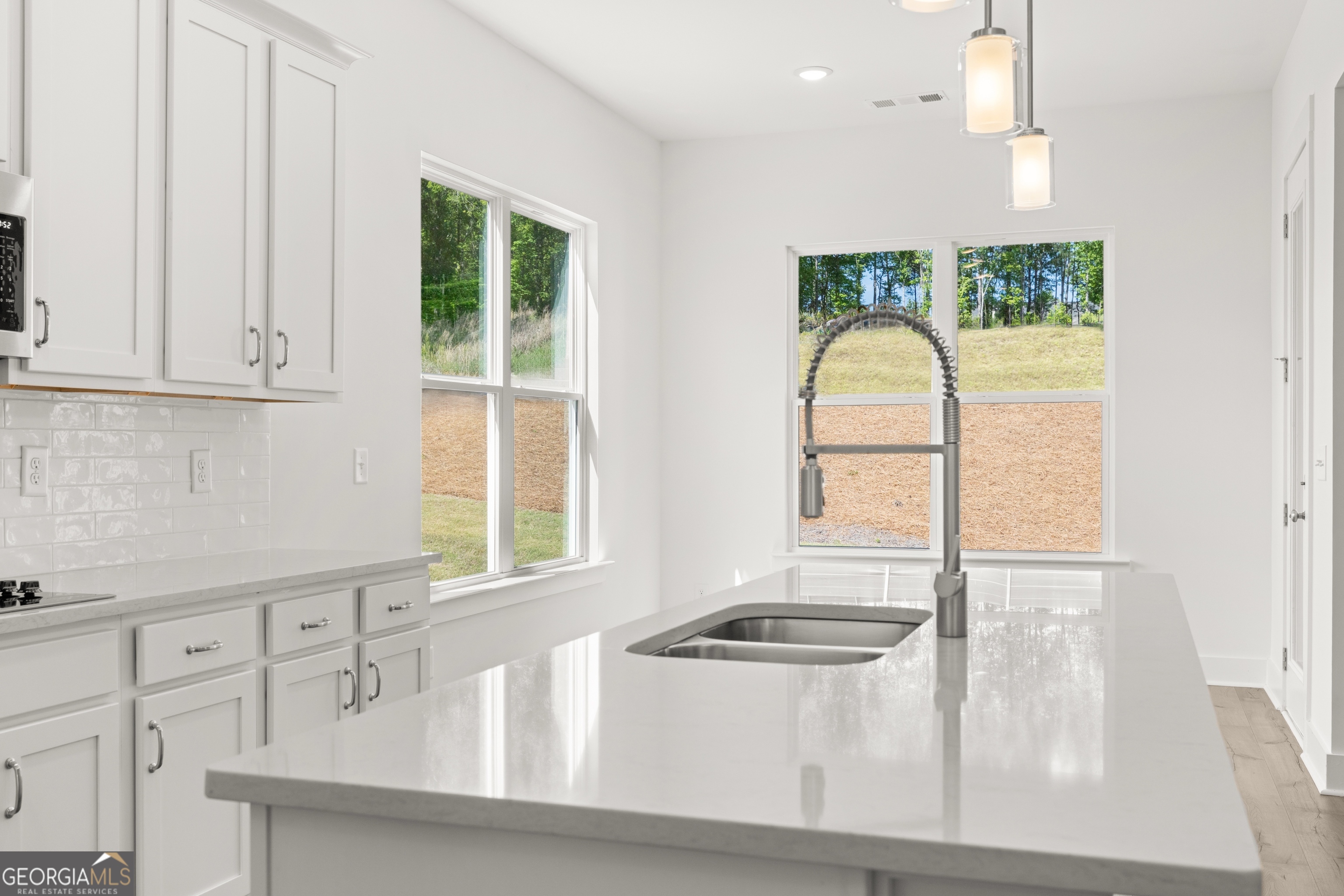 15 Overview Court Hoschton, GA 30548 - Photo 15 of 43 a kitchen with stainless steel appliances granite countertop a stove a sink and a white cabinets with wooden floor