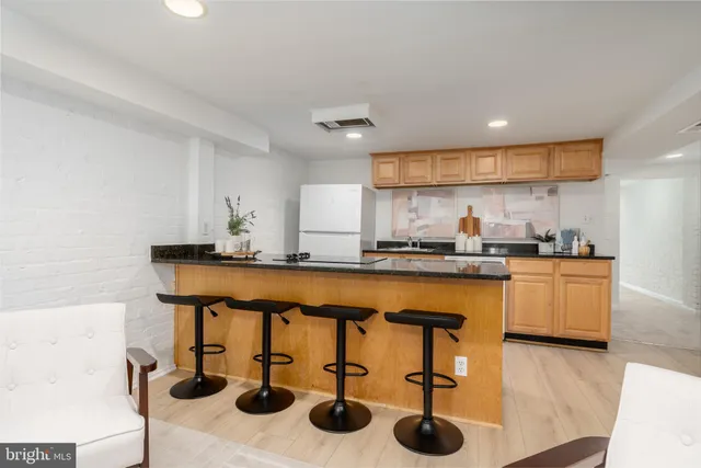 a kitchen with stainless steel appliances granite countertop a sink and a refrigerator