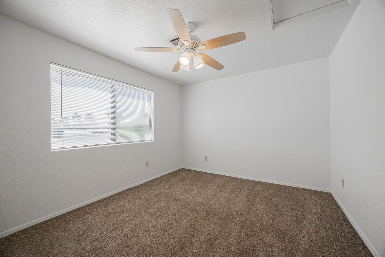 16033 North 25th Street, Unit 202 Phoenix, AZ 85032 - Photo 15 of 18 an empty room with a window and a fan