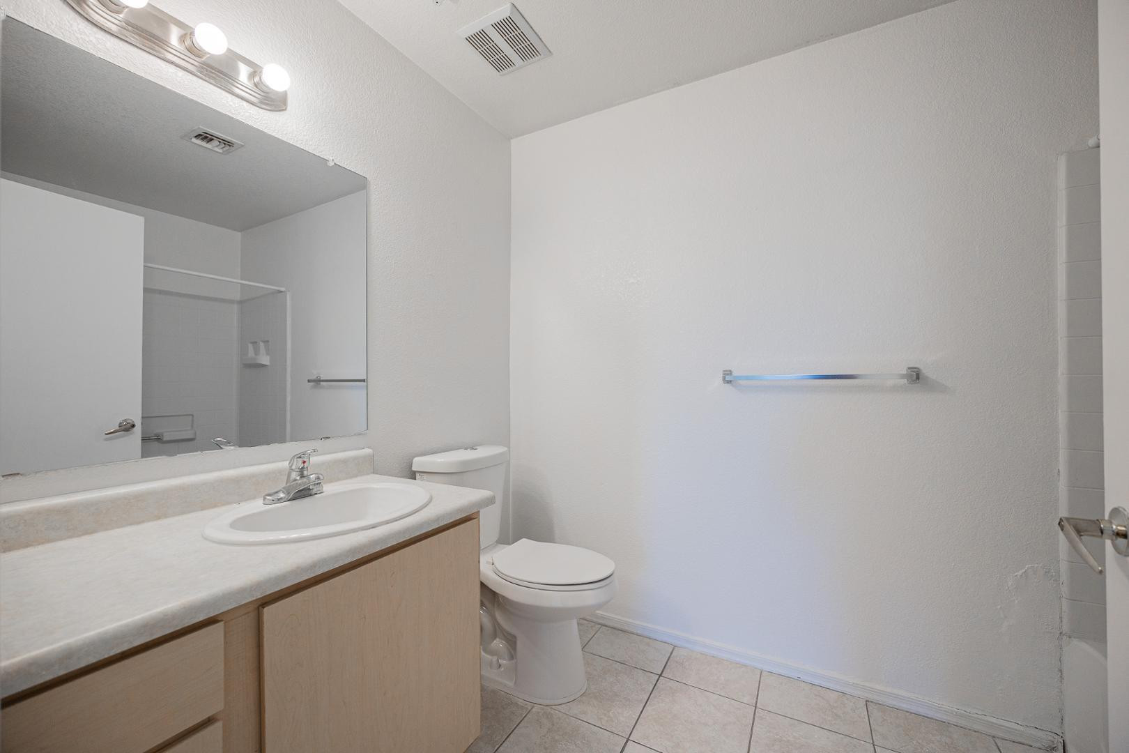 16033 North 25th Street, Unit 202 Phoenix, AZ 85032 - Photo 17 of 18 a bathroom with a granite countertop sink a toilet and a mirror